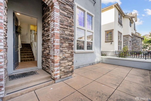 entrance to property with stone siding and stucco siding