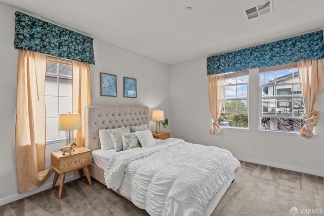 carpeted bedroom with baseboards and visible vents