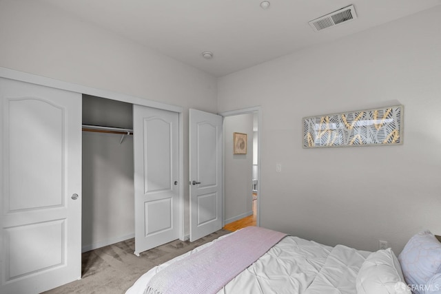 bedroom with visible vents, baseboards, carpet floors, and a closet