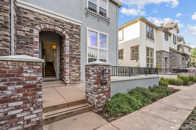 view of exterior entry with stone siding and stucco siding