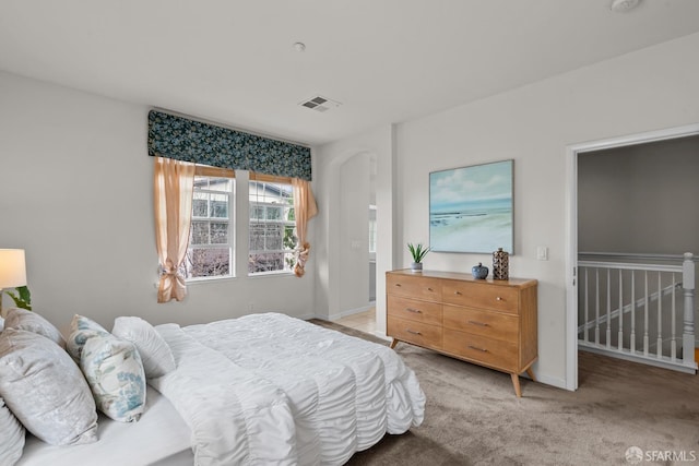 bedroom with visible vents, baseboards, and light colored carpet