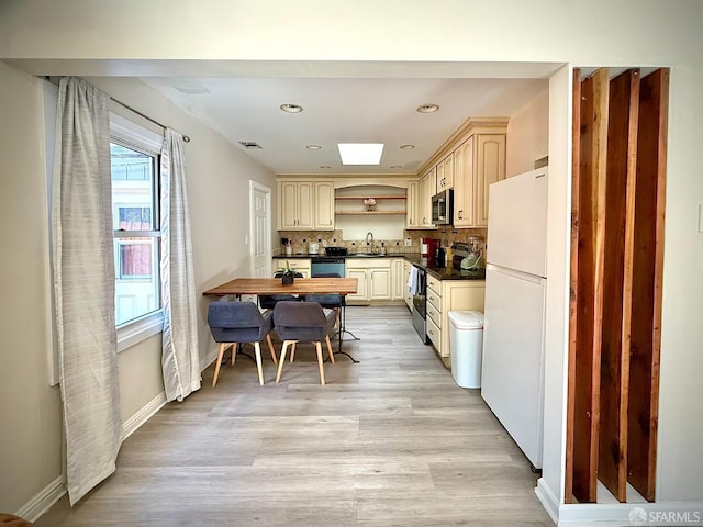 38002 Stenhammer Dr, Fremont, CA 94536 - kitchen featuring stainless steel appliances, dark countertops, a sink, decorative backsplash, and light wood-style floors