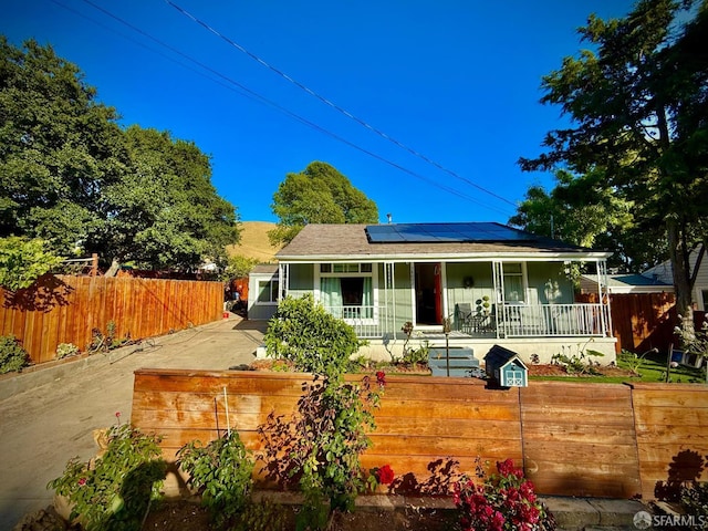 38002 Stenhammer Dr, Fremont, CA 94536 - rear view of property with covered porch, a fenced front yard, and solar panels