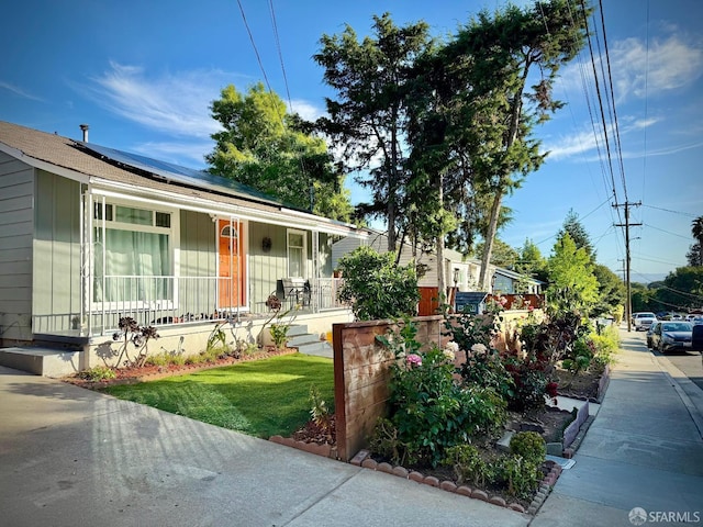 38002 Stenhammer Dr, Fremont, CA 94536 - view of front of home featuring covered porch, roof mounted solar panels, and a front yard