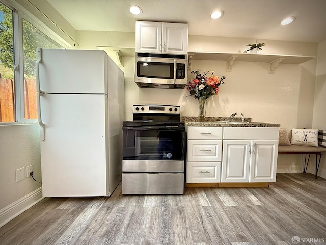 38002 Stenhammer Dr, Fremont, CA 94536 - kitchen with appliances with stainless steel finishes, light wood-style floors, white cabinetry, baseboards, and a sink