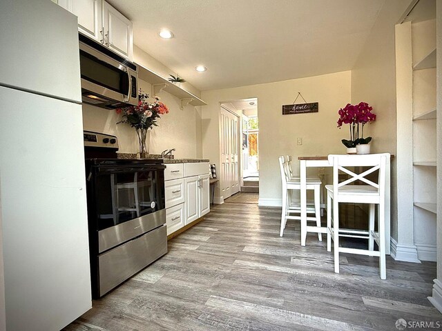 38002 Stenhammer Dr, Fremont, CA 94536 - kitchen featuring appliances with stainless steel finishes, wood finished floors, white cabinetry, recessed lighting, and baseboards