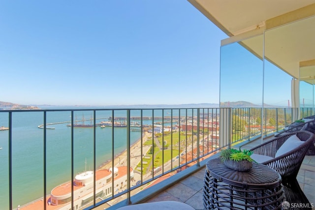 balcony featuring a water view and a view of the beach