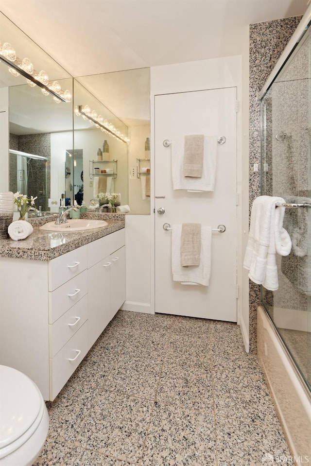 full bathroom with shower / bath combination with glass door, vanity, and toilet