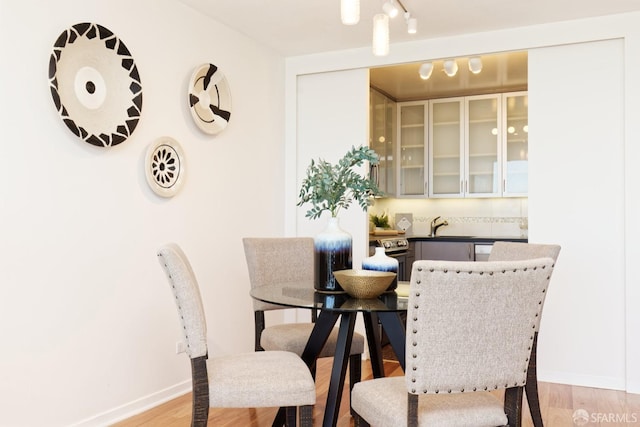 dining area with light wood-type flooring and sink