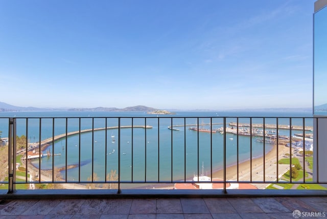 balcony featuring a water and mountain view and a beach view