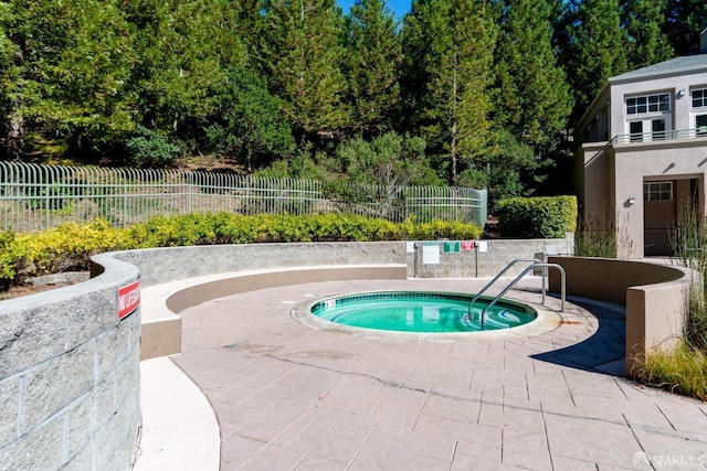 view of swimming pool featuring a hot tub and a patio area