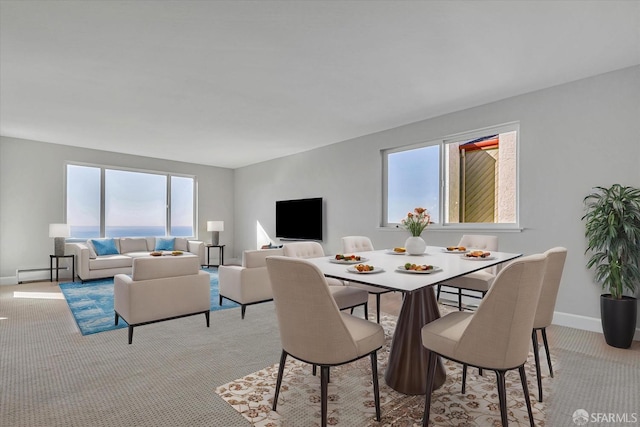 dining space with light colored carpet and a baseboard heating unit