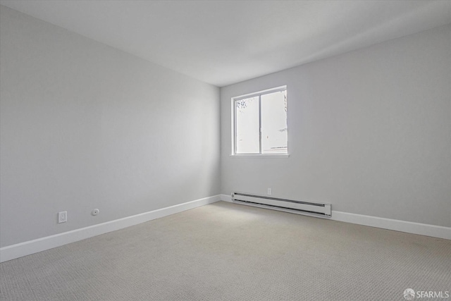 empty room featuring a baseboard heating unit and light colored carpet