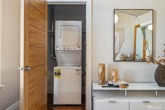 laundry area with stacked washer and clothes dryer and dark hardwood / wood-style flooring