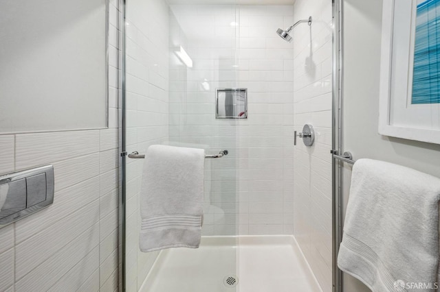 bathroom with tile walls and a shower with door