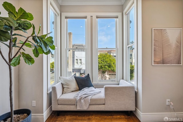 living area featuring crown molding, a healthy amount of sunlight, and dark hardwood / wood-style flooring