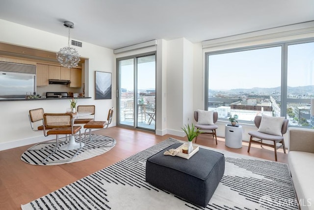 living room featuring a chandelier, light hardwood / wood-style flooring, and plenty of natural light