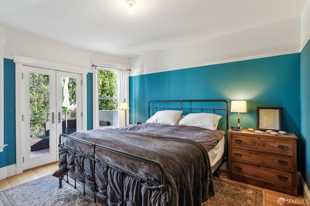 bedroom with access to outside, french doors, and wood-type flooring