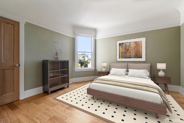 bedroom featuring ornamental molding and light hardwood / wood-style floors