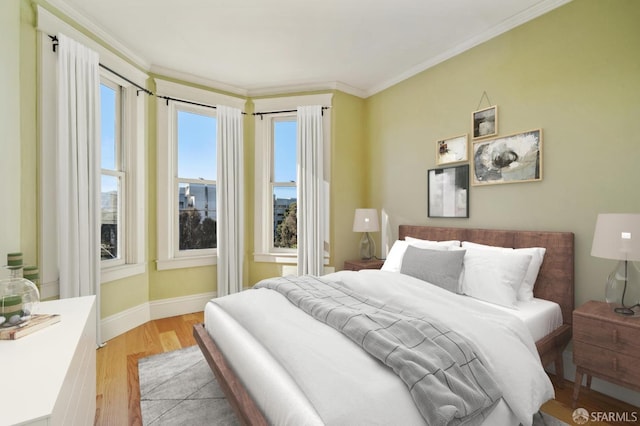 bedroom with light hardwood / wood-style floors and crown molding