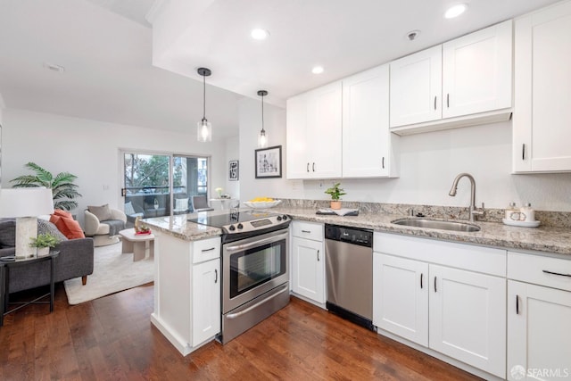 kitchen featuring appliances with stainless steel finishes, pendant lighting, white cabinetry, sink, and kitchen peninsula