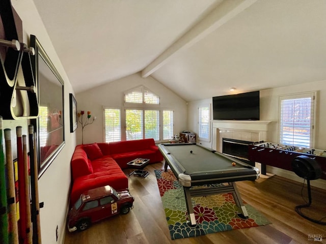 recreation room featuring vaulted ceiling with beams, hardwood / wood-style flooring, and a healthy amount of sunlight