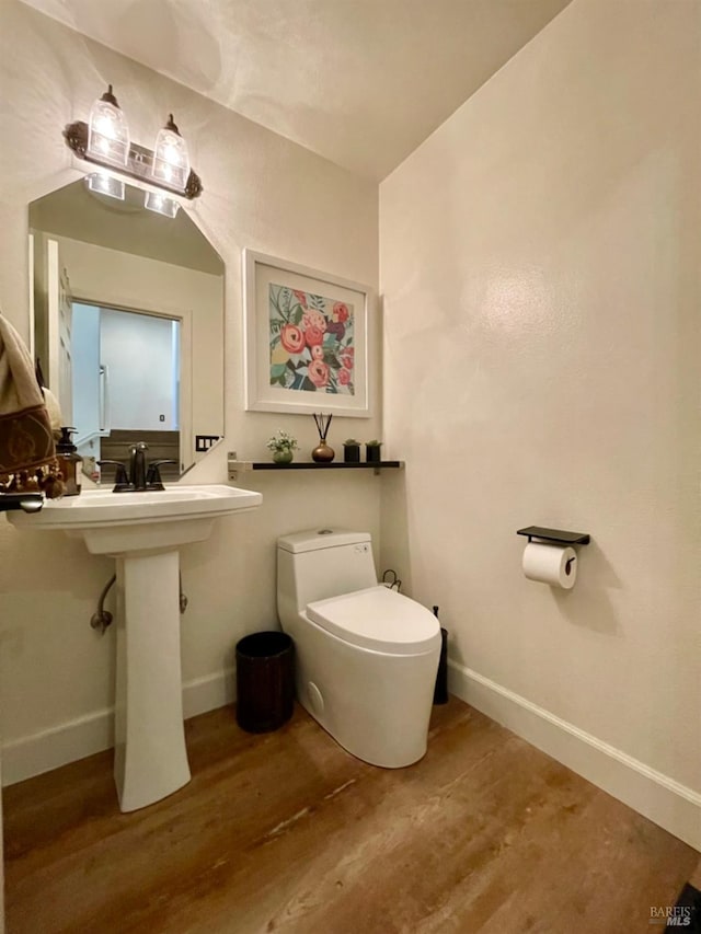 bathroom featuring wood-type flooring and toilet