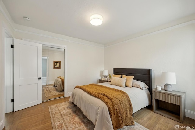 bedroom with hardwood / wood-style flooring and ornamental molding