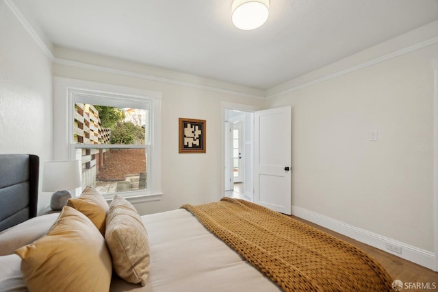 bedroom with hardwood / wood-style flooring and ornamental molding