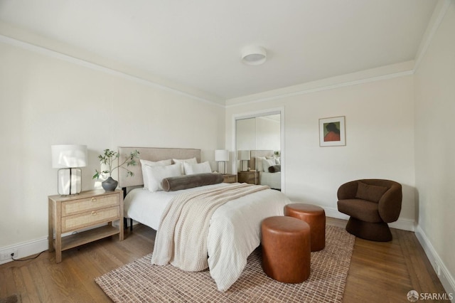 bedroom with crown molding, wood-type flooring, and a closet