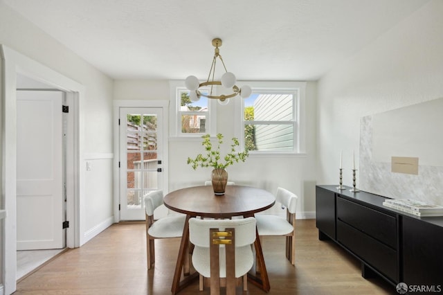 dining area featuring an inviting chandelier and light hardwood / wood-style flooring