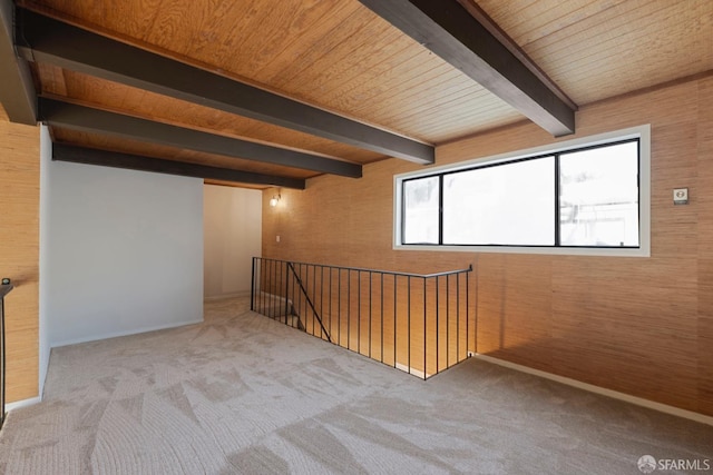 additional living space with light colored carpet, beam ceiling, and wooden walls