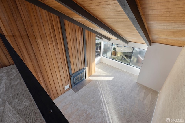 corridor featuring beamed ceiling, carpet, and wood ceiling