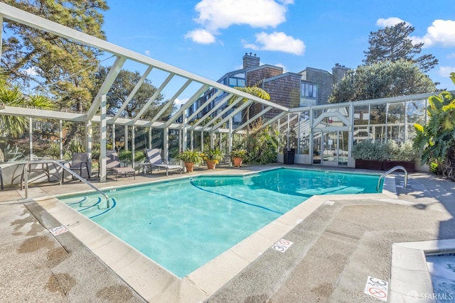 view of pool with a patio area and a lanai