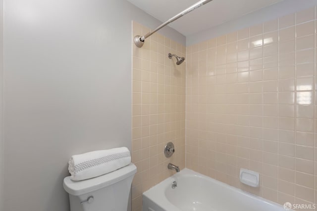 bathroom with toilet and tiled shower / bath combo