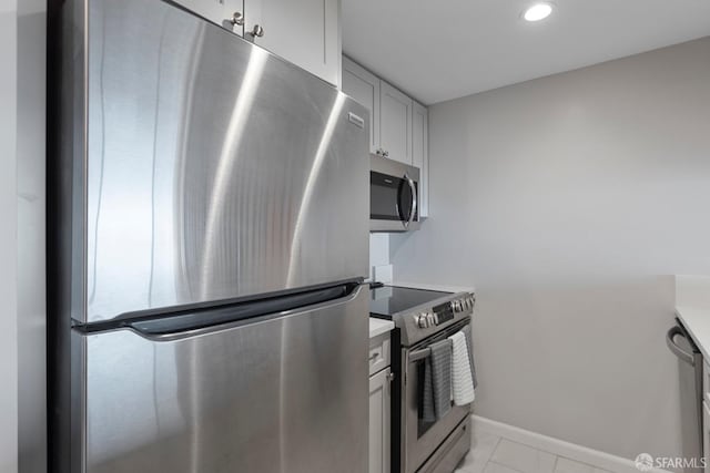 kitchen featuring baseboards, marble finish floor, stainless steel appliances, light countertops, and recessed lighting