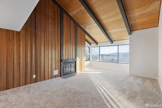 unfurnished living room featuring wood ceiling, a mountain view, wooden walls, vaulted ceiling with beams, and carpet flooring