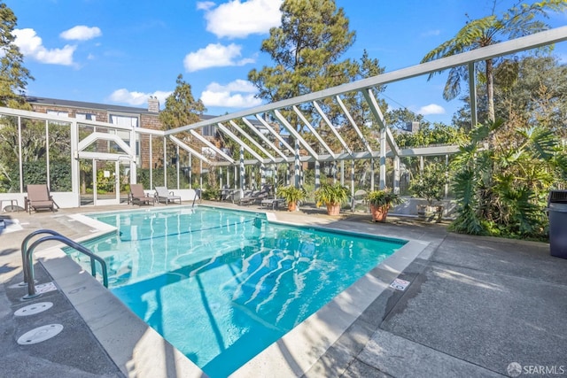 pool featuring glass enclosure and a patio