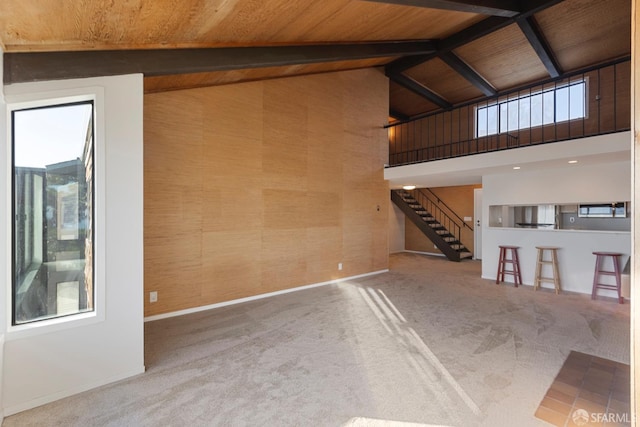 interior space with carpet flooring, wood ceiling, high vaulted ceiling, and beamed ceiling