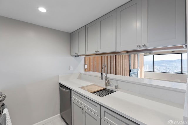 kitchen with gray cabinets, stainless steel dishwasher, sink, a mountain view, and light tile patterned flooring