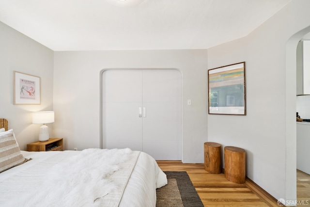600 Ellsworth St, San Francisco, CA 94110 - bedroom featuring arched walkways, light wood-style flooring, and a closet
