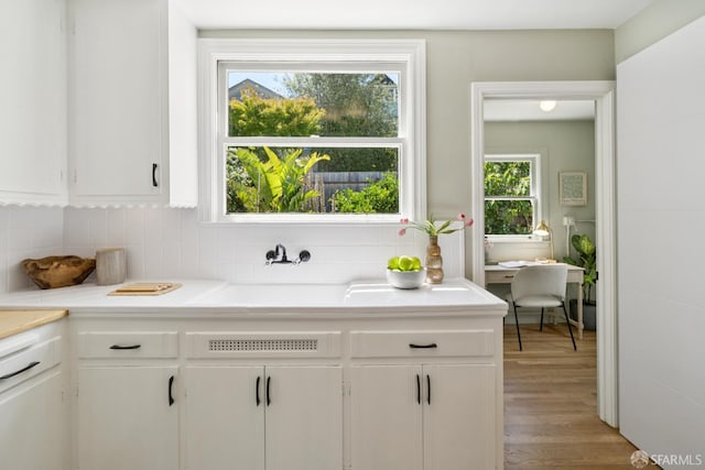 600 Ellsworth St, San Francisco, CA 94110 - kitchen with light countertops, white cabinetry, decorative backsplash, and light wood-style floors