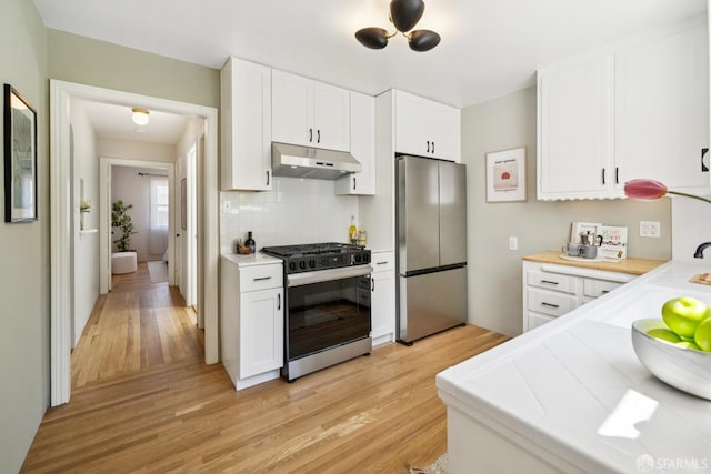 600 Ellsworth St, San Francisco, CA 94110 - kitchen featuring stainless steel appliances, under cabinet range hood, light wood-style floors, and white cabinets