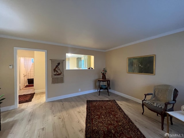 living area featuring light wood finished floors, baseboards, and ornamental molding