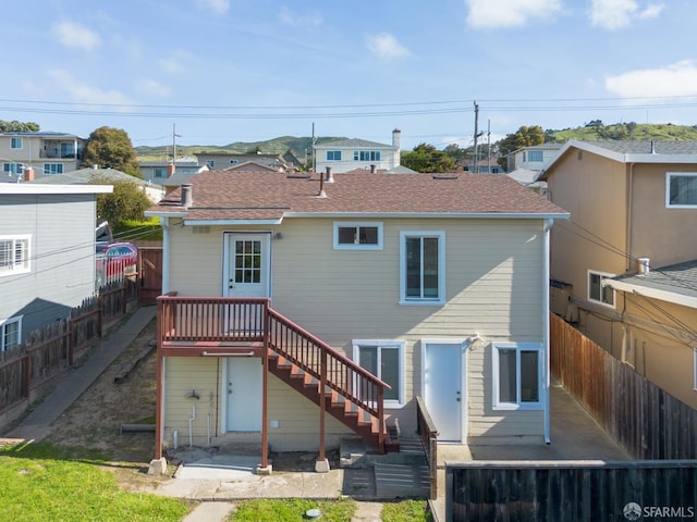 rear view of property featuring a fenced backyard and stairs