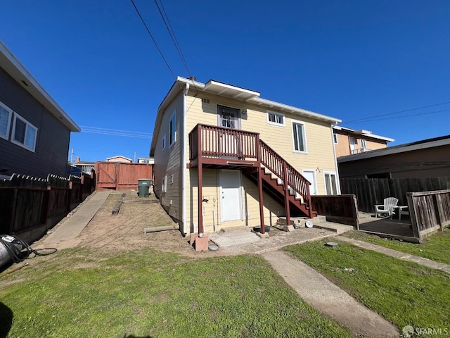 rear view of house with a yard, a fenced backyard, a patio area, stairs, and a deck