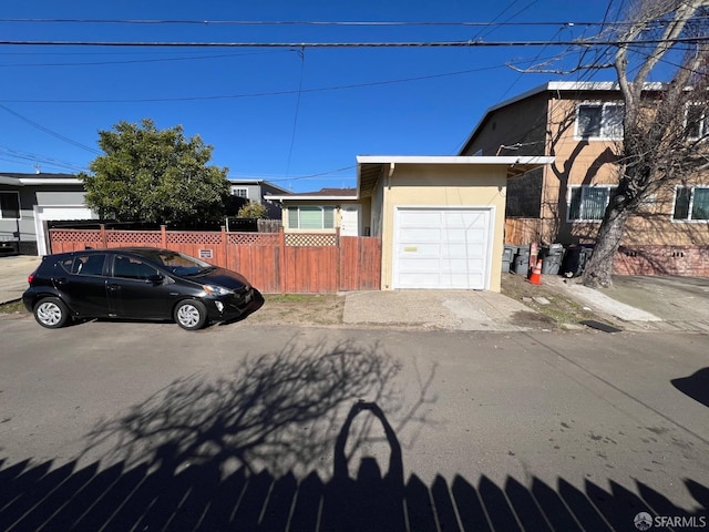 view of front of home featuring an attached garage, aphalt driveway, stucco siding, and fence