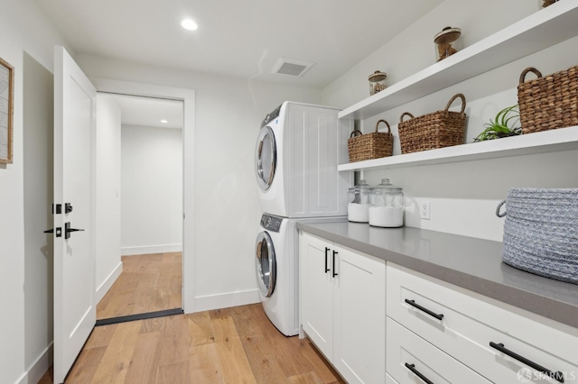 2031 Buena Vista Dr, Pinole, CA 94564 - laundry area featuring stacked washer and clothes dryer, cabinet space, light wood-style floors, recessed lighting, and baseboards