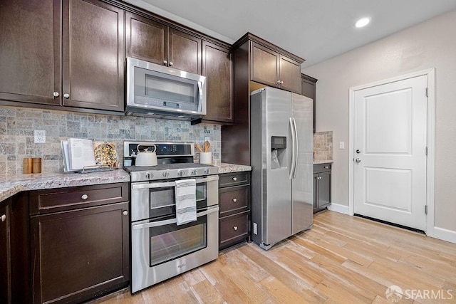192 Montevina Way, Hayward, CA 94545 - kitchen featuring appliances with stainless steel finishes, dark brown cabinetry, tasteful backsplash, light wood finished floors, and light stone countertops