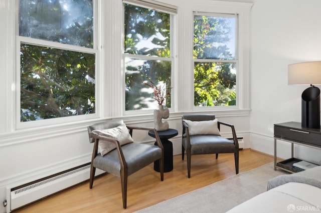 sitting room with light hardwood / wood-style floors and a baseboard radiator